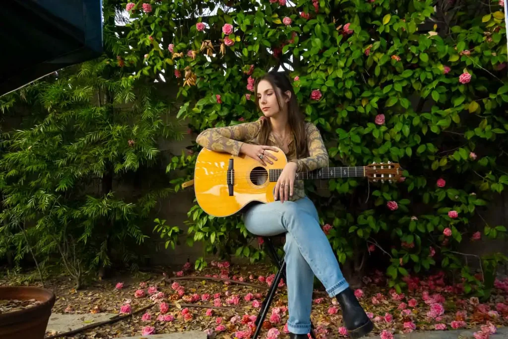 Abbi Berry sitting with acoustic guitar