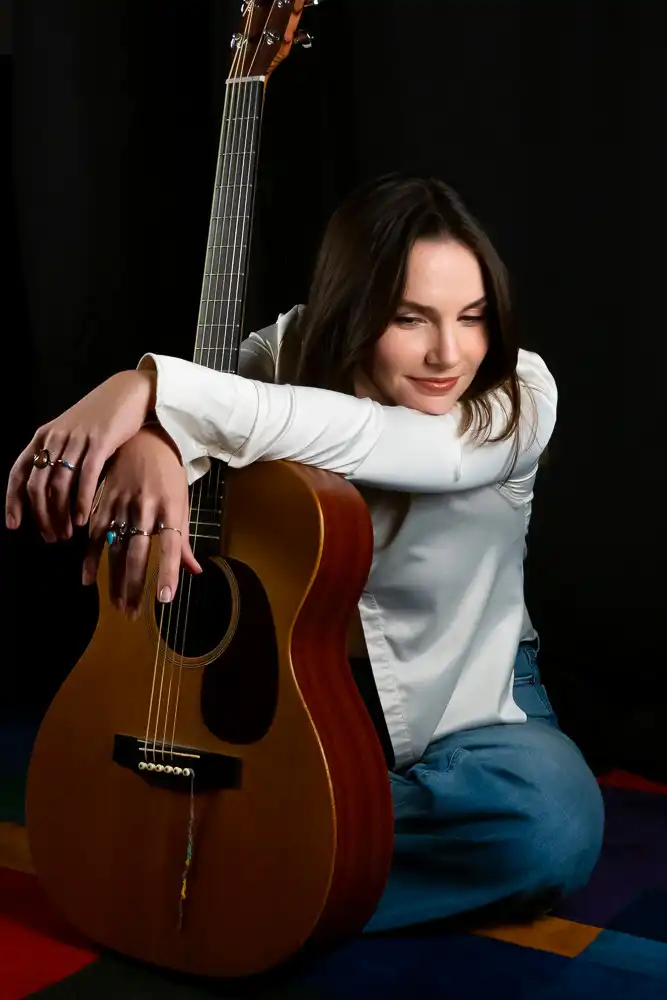 Abbi Berry sitting and holding guitar
